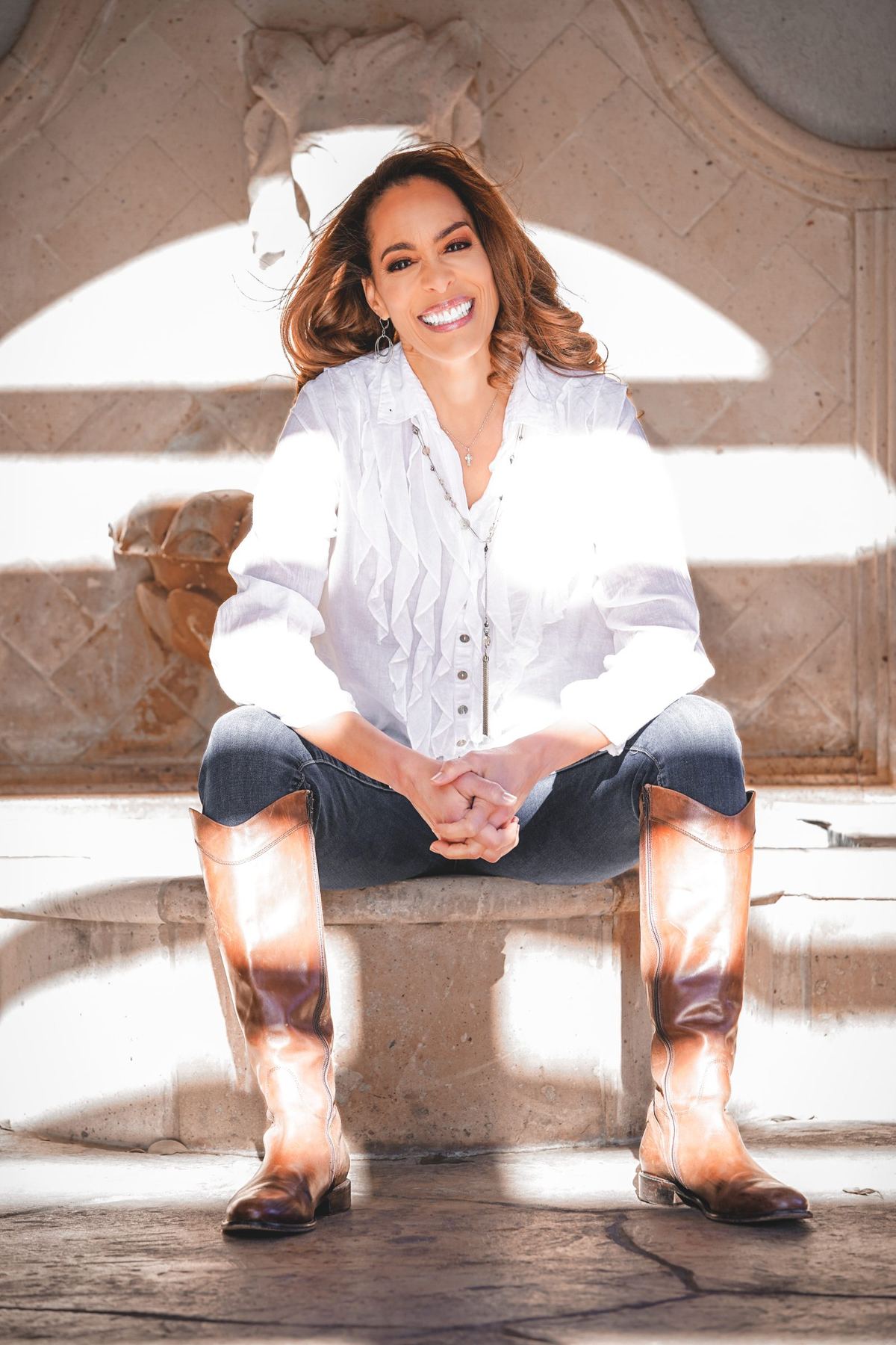 Portrait of Dr. Angela Walker seated on stone steps during an on-location brand session