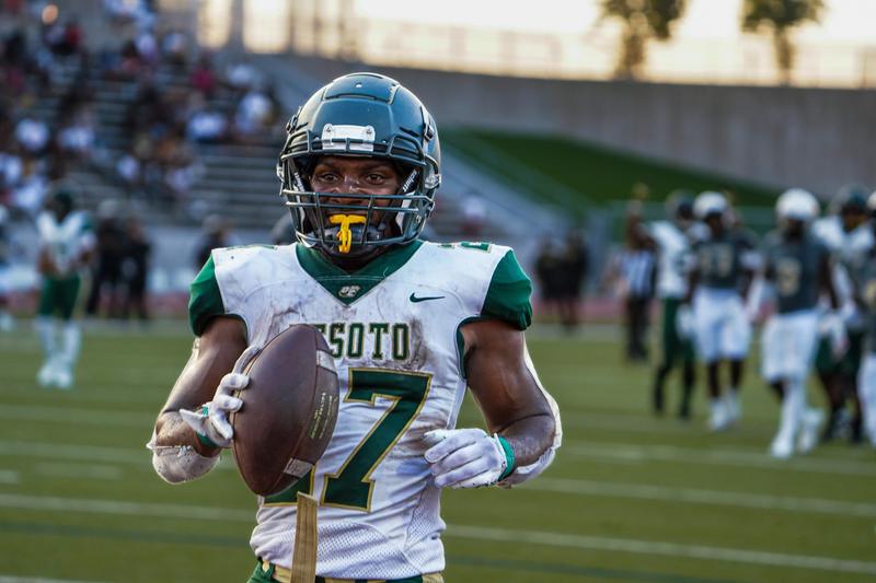 Close-up of a DeSoto high school football player wearing a helmet and number 7 jersey on the field.