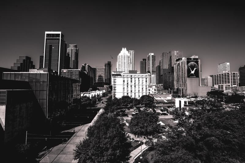 Black and white cityscape view of downtown Austin skyscrapers, including the Frost Bank Tower.